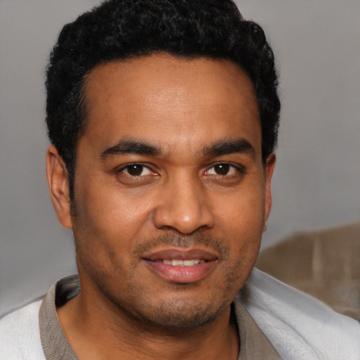 Joyful black young-adult male with short  black hair and brown eyes