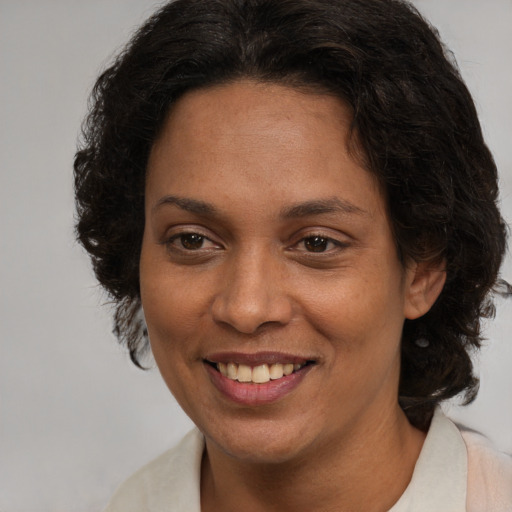 Joyful latino adult female with medium  brown hair and brown eyes