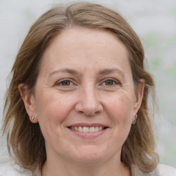 Joyful white adult female with medium  brown hair and grey eyes