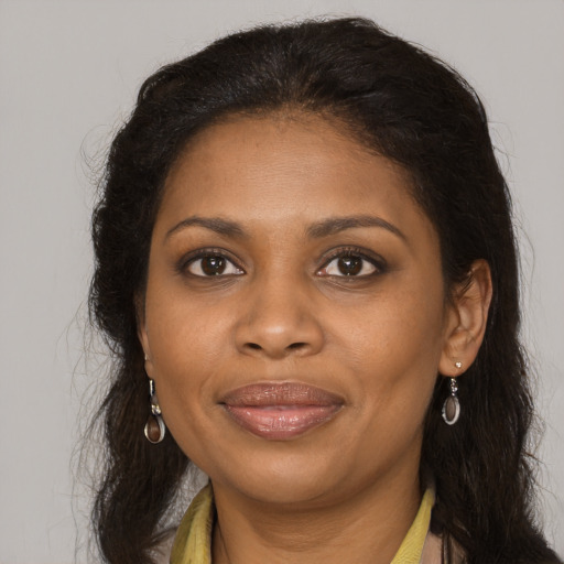Joyful black young-adult female with long  brown hair and brown eyes