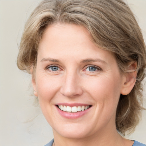 Joyful white young-adult female with medium  brown hair and blue eyes