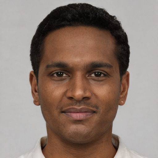 Joyful black young-adult male with short  brown hair and brown eyes