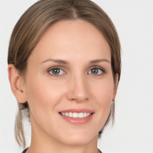 Joyful white young-adult female with medium  brown hair and grey eyes