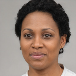 Joyful black adult female with short  black hair and brown eyes