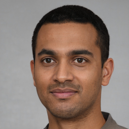 Joyful black young-adult male with short  black hair and brown eyes