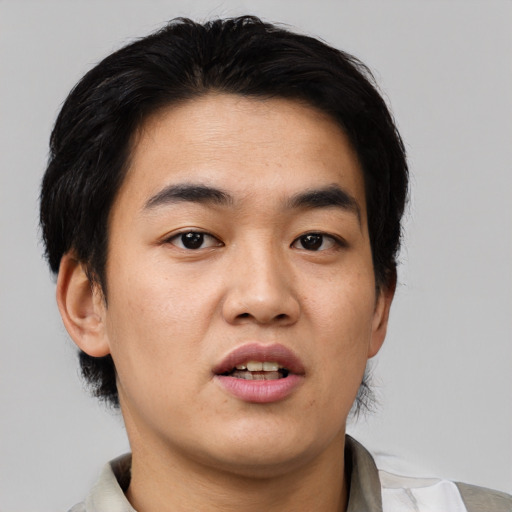 Joyful asian young-adult male with short  black hair and brown eyes