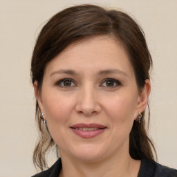 Joyful white young-adult female with medium  brown hair and grey eyes