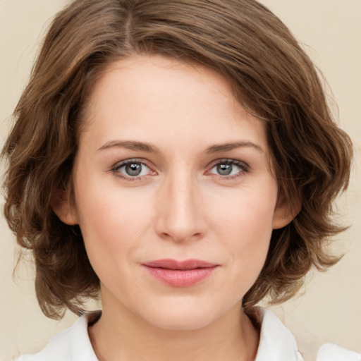 Joyful white young-adult female with medium  brown hair and green eyes