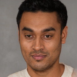 Joyful latino young-adult male with short  black hair and brown eyes