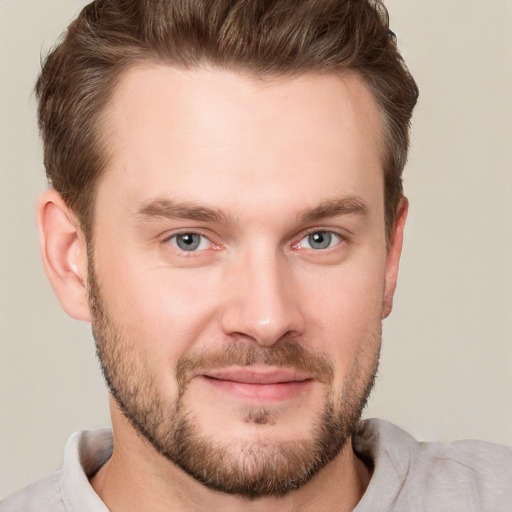 Joyful white young-adult male with short  brown hair and grey eyes