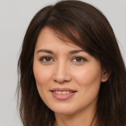 Joyful white young-adult female with long  brown hair and brown eyes