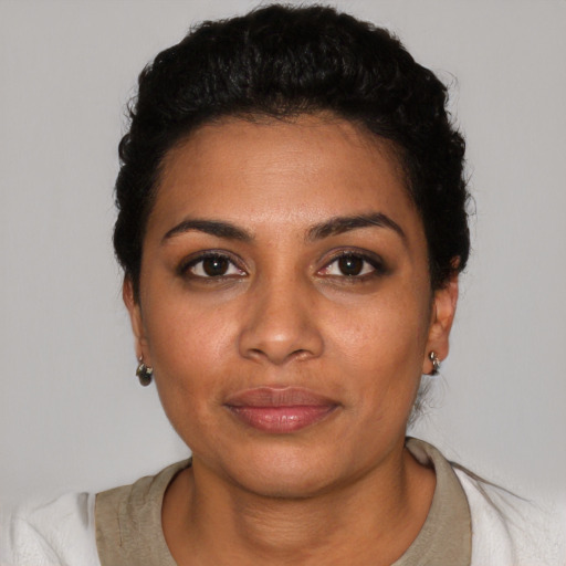 Joyful latino young-adult female with short  black hair and brown eyes