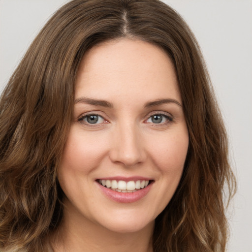 Joyful white young-adult female with long  brown hair and green eyes