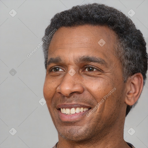 Joyful black adult male with short  black hair and brown eyes