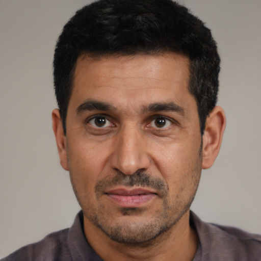 Joyful white adult male with short  black hair and brown eyes