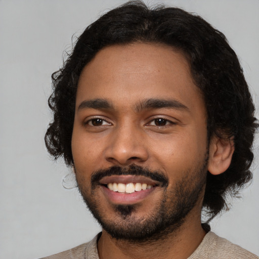 Joyful black young-adult male with short  brown hair and brown eyes