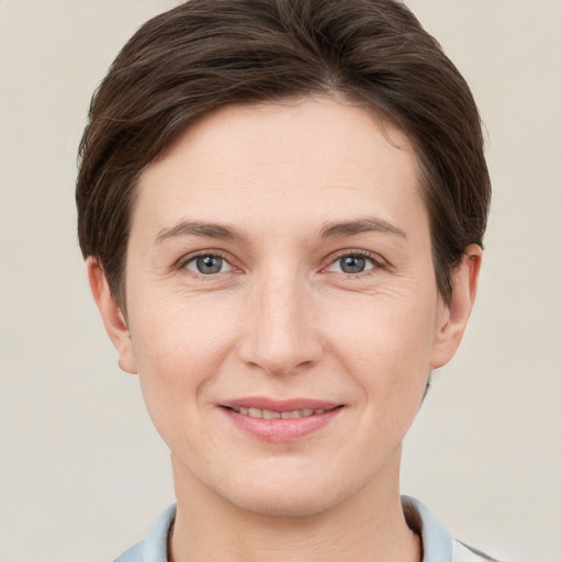 Joyful white young-adult female with short  brown hair and grey eyes