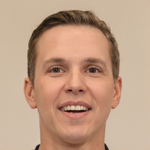 Joyful white young-adult male with short  brown hair and brown eyes