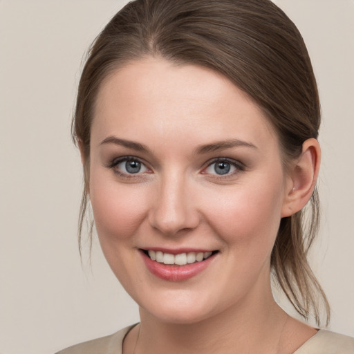 Joyful white young-adult female with medium  brown hair and grey eyes