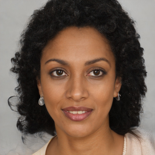 Joyful black young-adult female with long  brown hair and brown eyes