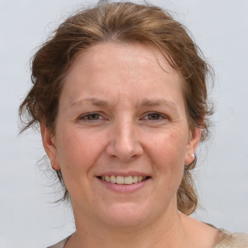 Joyful white adult female with medium  brown hair and grey eyes