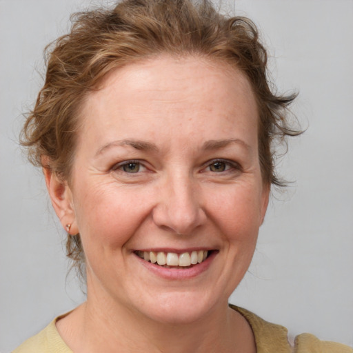 Joyful white adult female with medium  brown hair and blue eyes