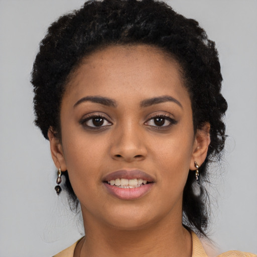 Joyful black young-adult female with long  black hair and brown eyes