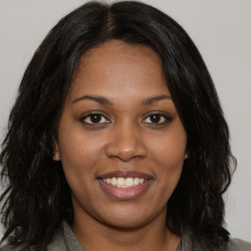 Joyful black young-adult female with medium  brown hair and brown eyes