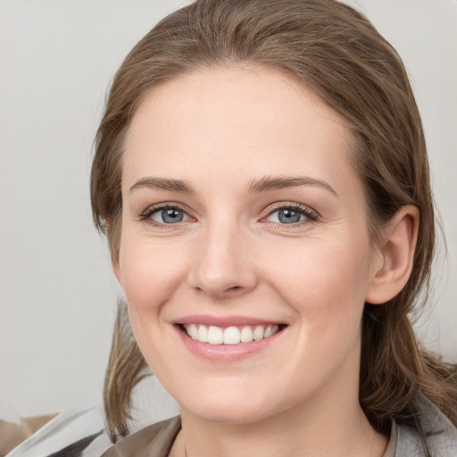 Joyful white young-adult female with medium  brown hair and grey eyes