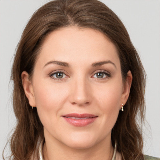 Joyful white young-adult female with medium  brown hair and green eyes