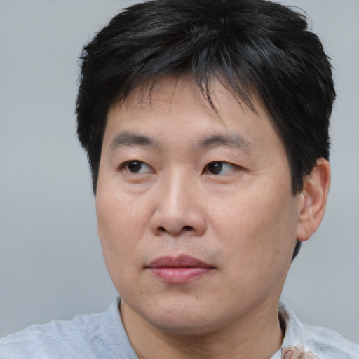 Joyful asian adult male with short  brown hair and brown eyes