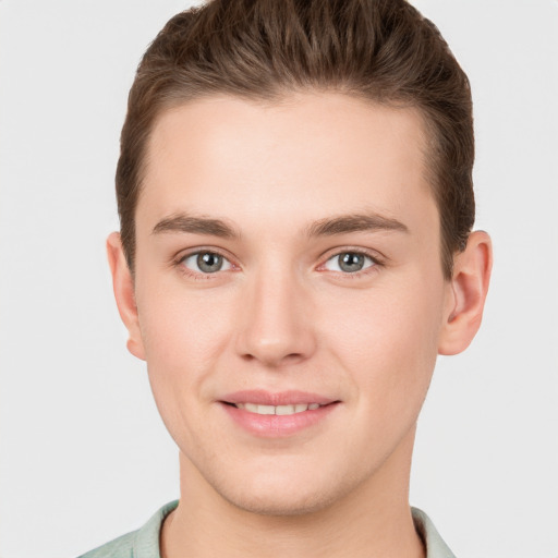 Joyful white young-adult male with short  brown hair and grey eyes