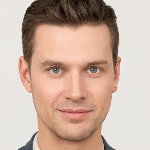 Joyful white young-adult male with short  brown hair and grey eyes