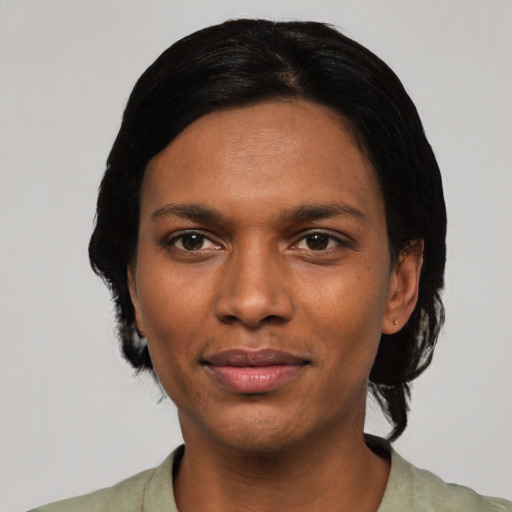 Joyful black young-adult female with short  black hair and brown eyes