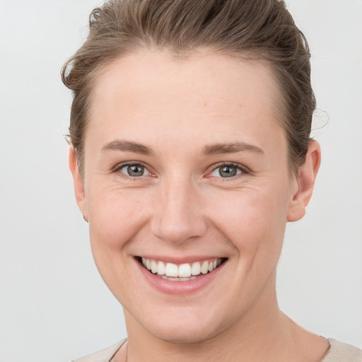 Joyful white young-adult female with short  brown hair and grey eyes