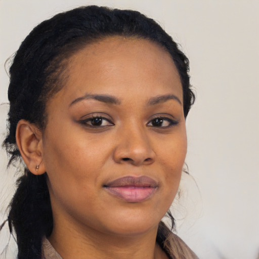 Joyful black young-adult female with long  brown hair and brown eyes