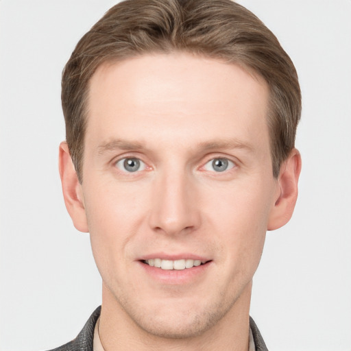 Joyful white young-adult male with short  brown hair and grey eyes