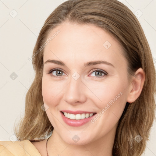 Joyful white young-adult female with long  brown hair and green eyes