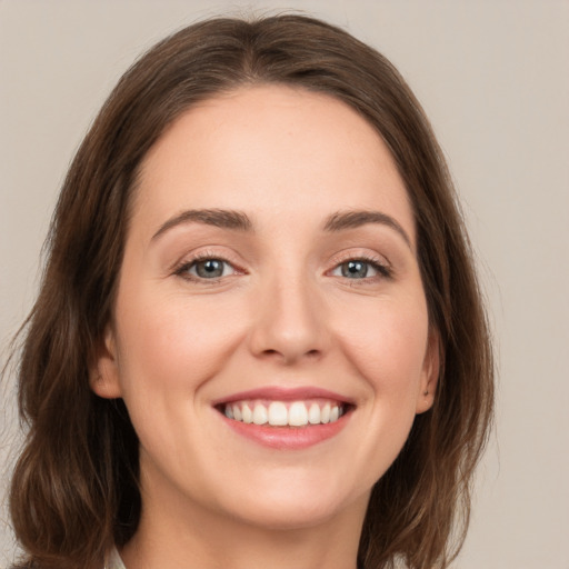 Joyful white young-adult female with medium  brown hair and green eyes