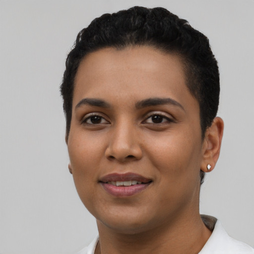 Joyful latino young-adult female with short  black hair and brown eyes
