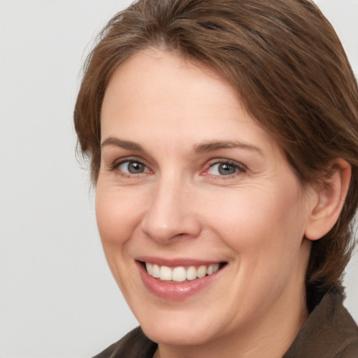 Joyful white adult female with medium  brown hair and brown eyes