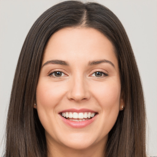 Joyful white young-adult female with long  brown hair and brown eyes