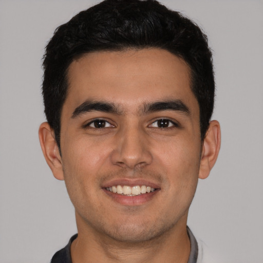 Joyful latino young-adult male with short  brown hair and brown eyes