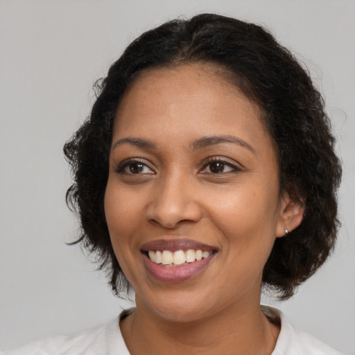 Joyful black young-adult female with medium  brown hair and brown eyes
