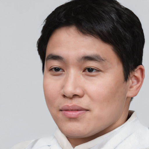Joyful asian young-adult male with short  black hair and brown eyes