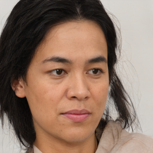 Joyful latino adult female with medium  brown hair and brown eyes