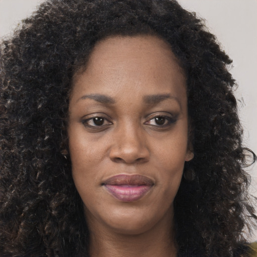 Joyful black young-adult female with long  brown hair and brown eyes