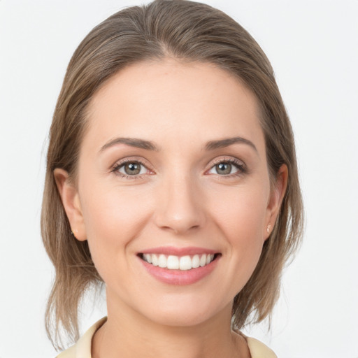 Joyful white young-adult female with medium  brown hair and grey eyes