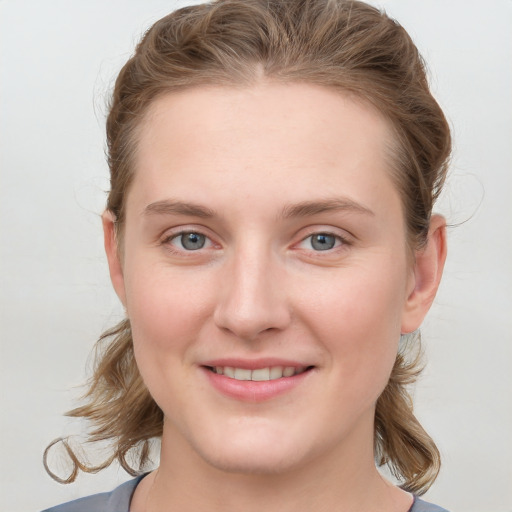 Joyful white young-adult female with medium  brown hair and blue eyes