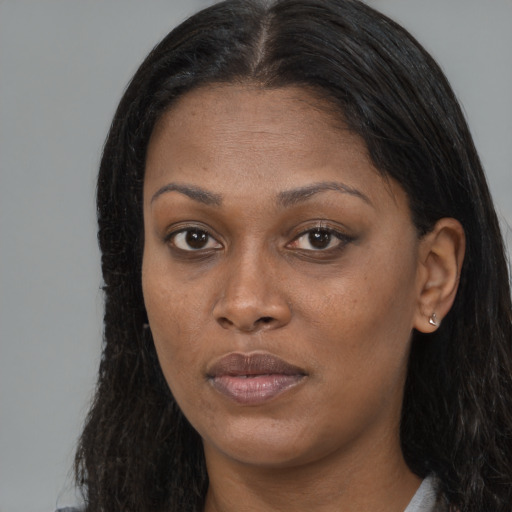 Joyful black young-adult female with long  brown hair and brown eyes